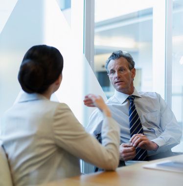 two finance professionals having a conversation in a modern office space